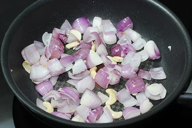 frying onions cashews to make kadai paneer gravy recipe