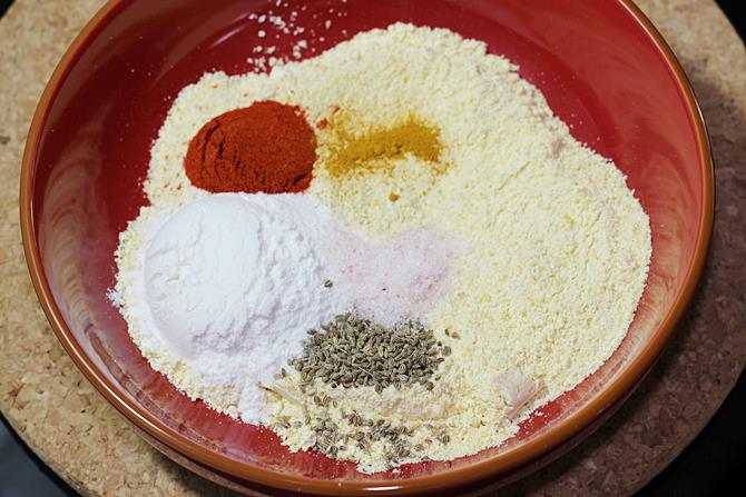 adding ingredients to make bread pakora batter