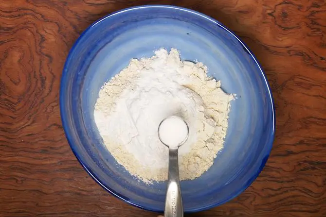 adding salt to flour to make mysore bonda