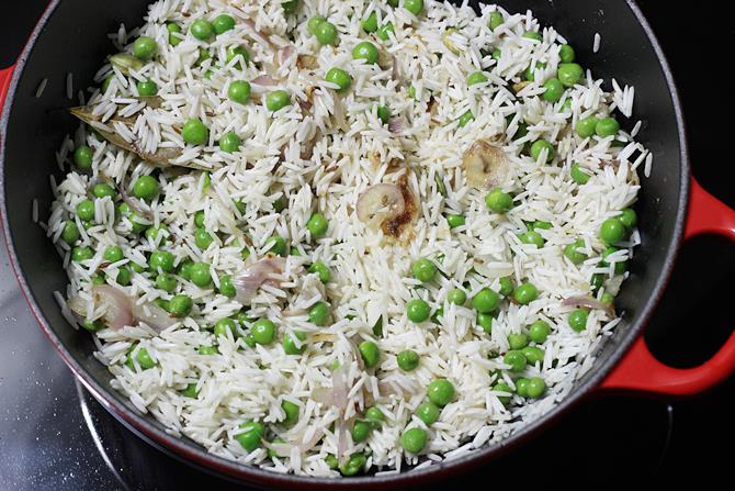 frying rice to make green peas pulav