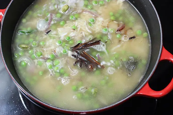 pouring water to make matar pulao