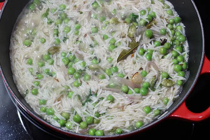 cooking rice in pot to make matar pulao