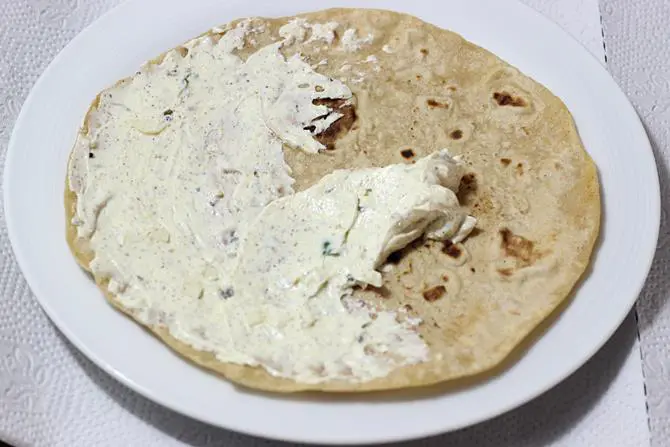 Smear the prepared spread over the roti including edges