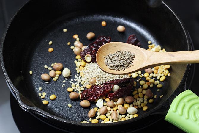 adding cumin to make podi idli