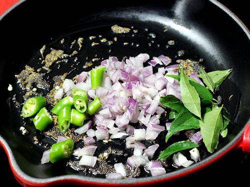 frying onions chilies to make poha