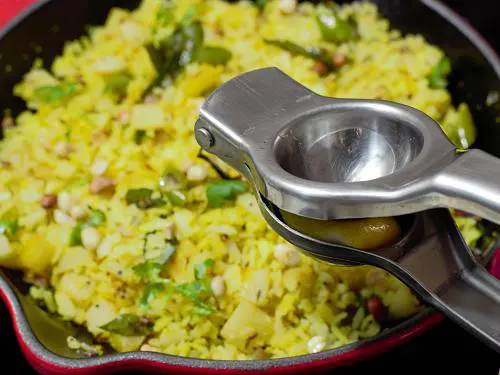 adding lemon juice to aloo poha