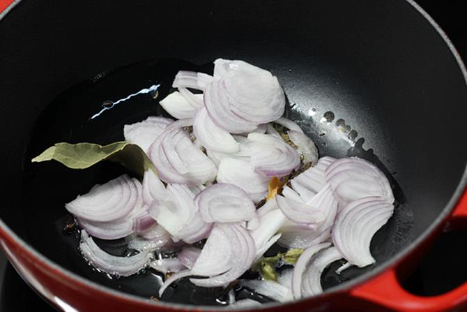 frying onion chilies to make tomato biryani