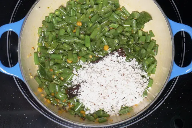 adding coconut to make french beans