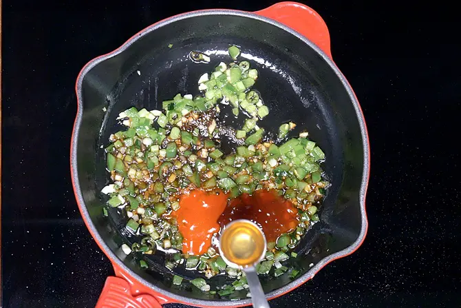 adding sauces and vinegar to make gobi manchurian