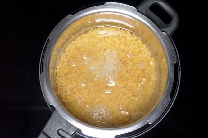 Rinsing dal and adding to cooker to make dal fry recipe