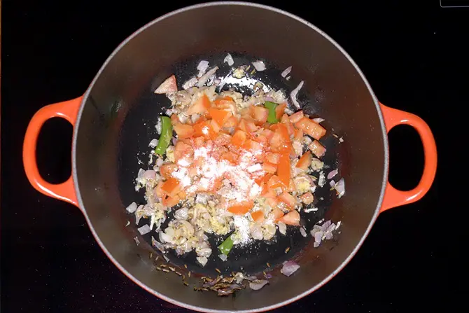 adding tomatoes with salt