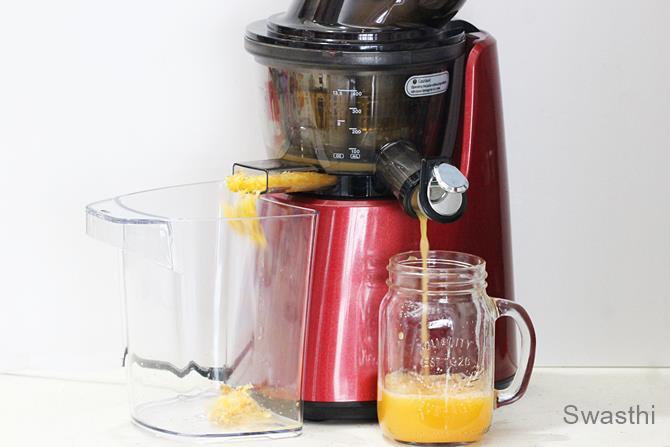 making orange juice in a slow juicer