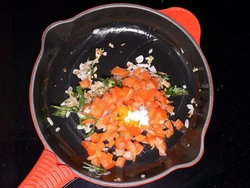 adding tomatoes salt to make bread upma