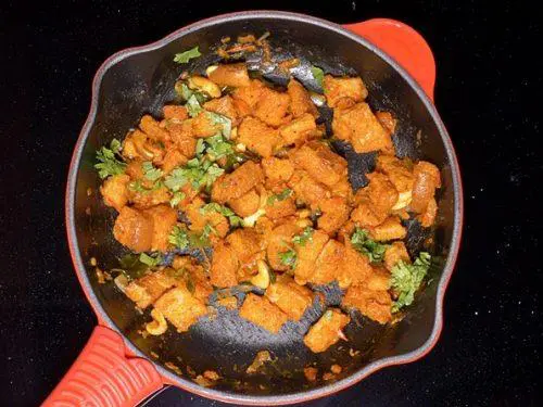 tossing bread in onion tomato masala to make bread upma