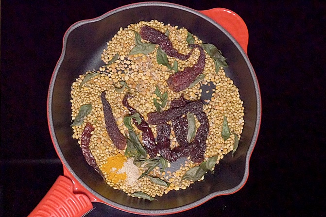 Adding turmeric to make sambar powder