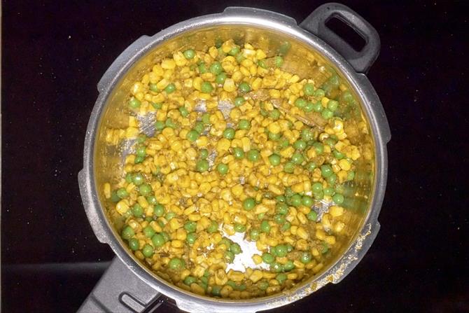 frying corn peas to make corn pulao