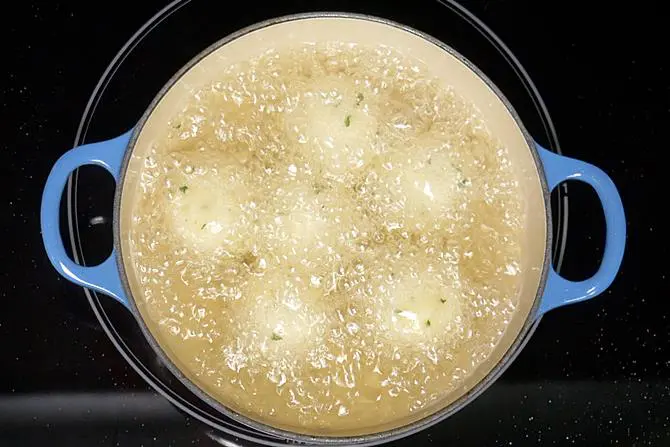 frying kofta in oil to make malai kofta