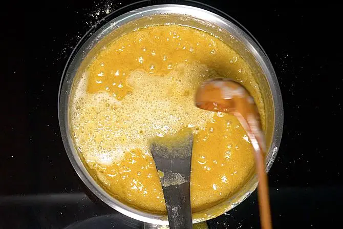 pouring hot ghee to mysore pak mixture