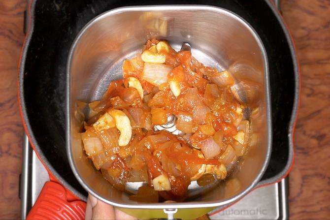 adding cooked onion tomatoes to blender to make kadai mushroom recipe