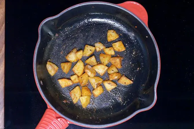 tossing spiced potatoes until crisp to make aloo chaat