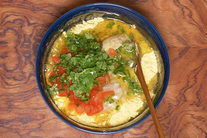 adding coriander leaves and water to make besan chilla