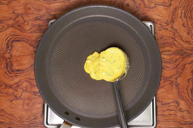 pouring cheela batter on tawa to make besan chilla