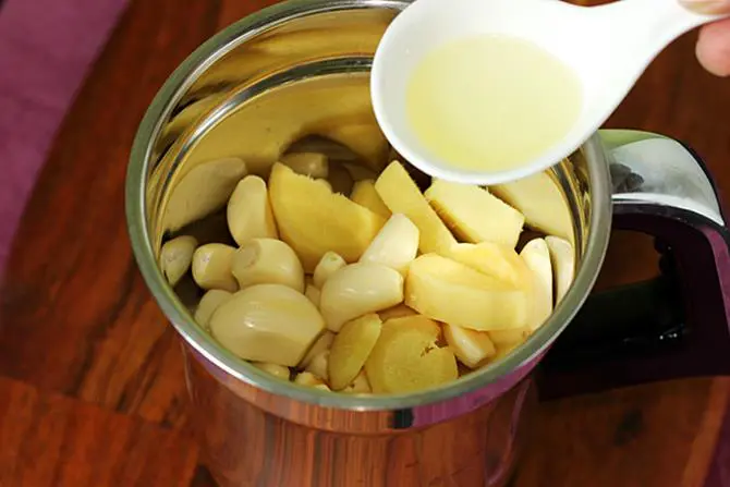 adding garlic cloves and ginger to jar