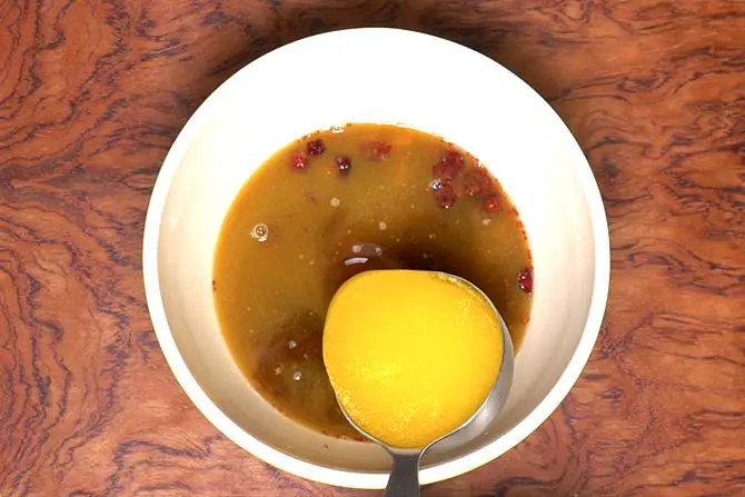 Pour melted butter to make eggless fruit cake