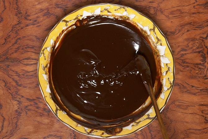 smooth melted chocolate ready to go over eggless sponge cake 
