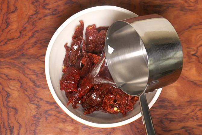 pour hot water to soak chilies for schezwan sauce