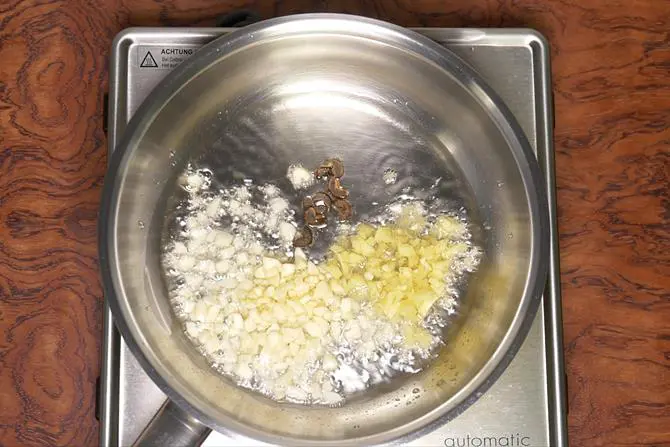 frying ginger garlic to make schezwan sauce