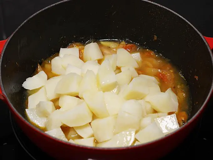 Adding the boiled potatoes to make poori curry
