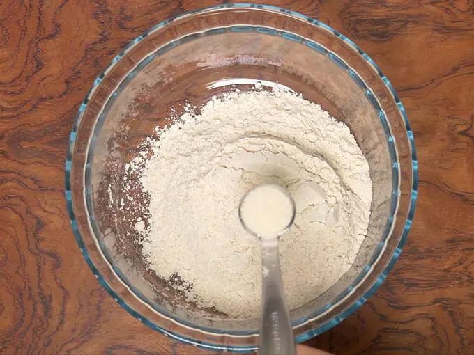 adding flour and semolina to bowl for puri recipe