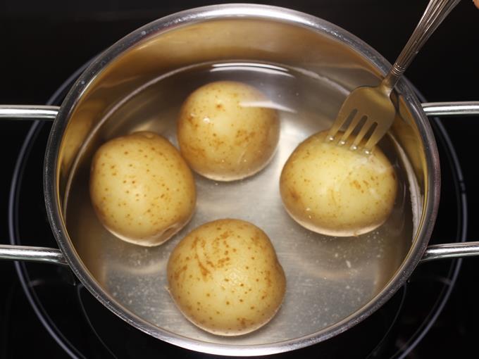 boiling potatoes in a pot to make jeera aloo
