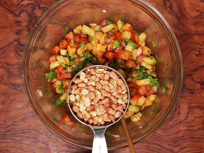 Adding roasted peanuts to make jhal muri