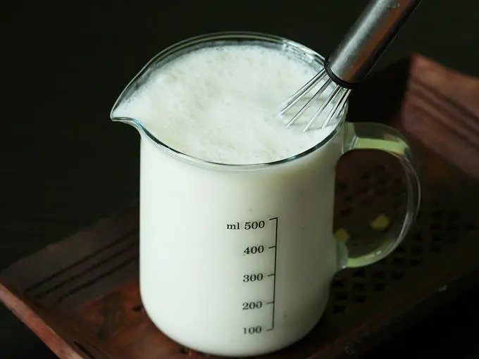 pouring water to whisk curd 