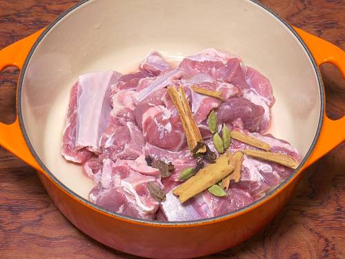 adding whole spices to make goat korma