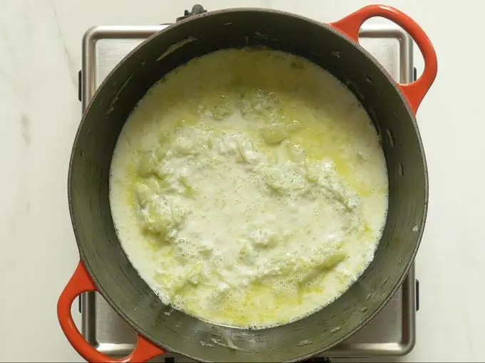 pouring hot milk to make lauki ka halwa