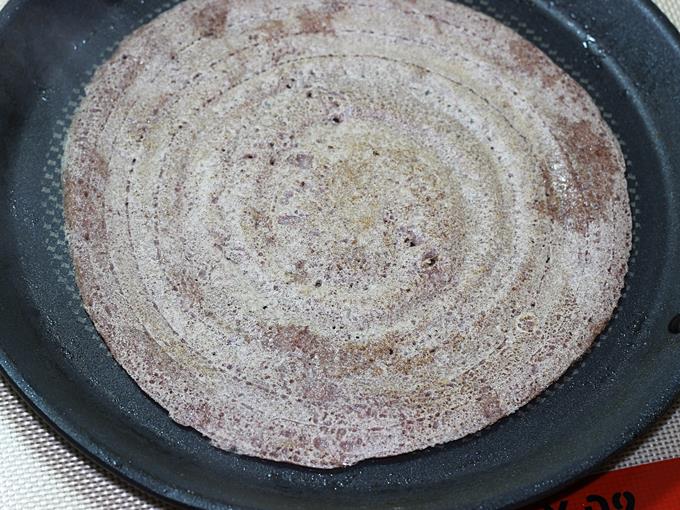 flipping ragi dosa to cook on the other side