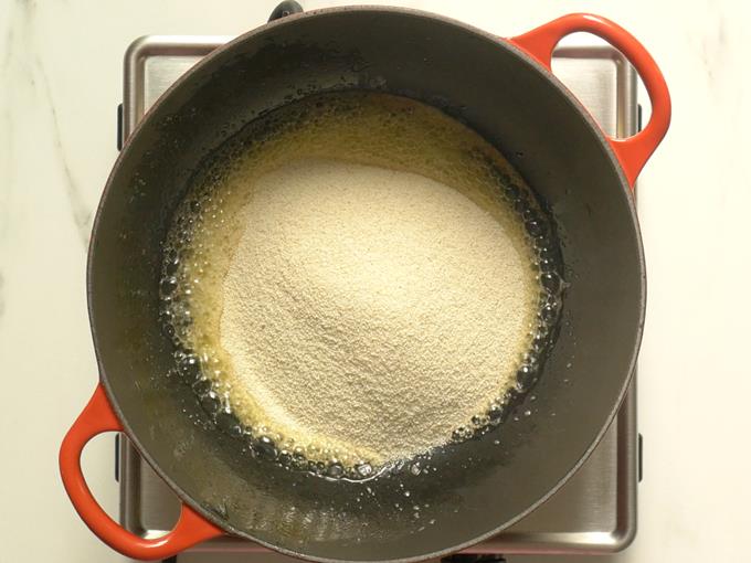 Mixing rava with ghee to make rava kesari recipe