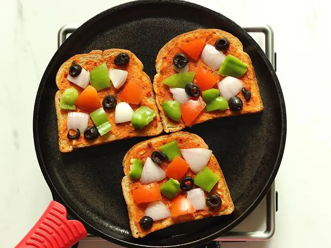 layer veggies on bread to make bread pizza