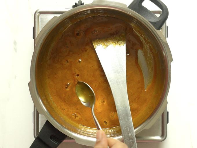 adding ghee to syrup to make chikki recipe