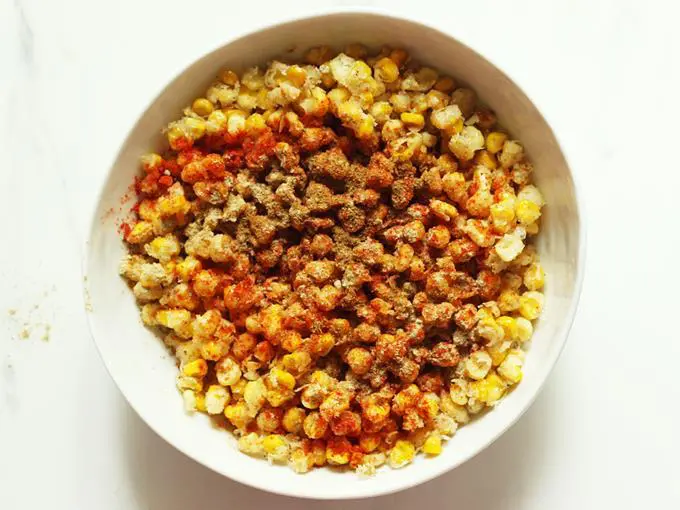 Sprinkle red chilli powder on corn