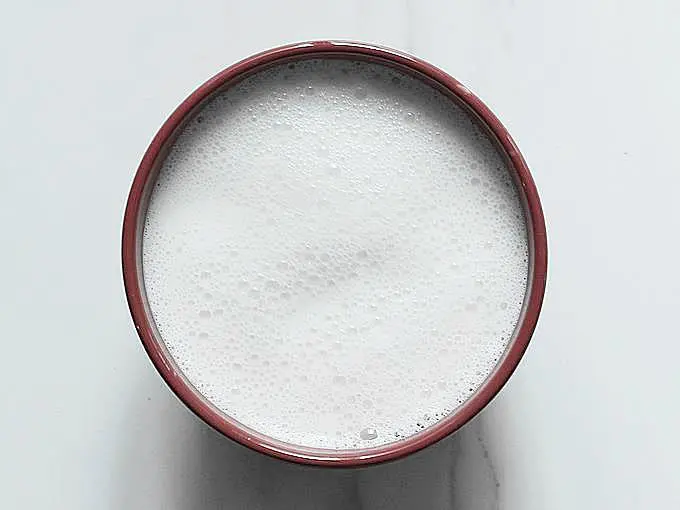 frothy milk in a bowl to make curd