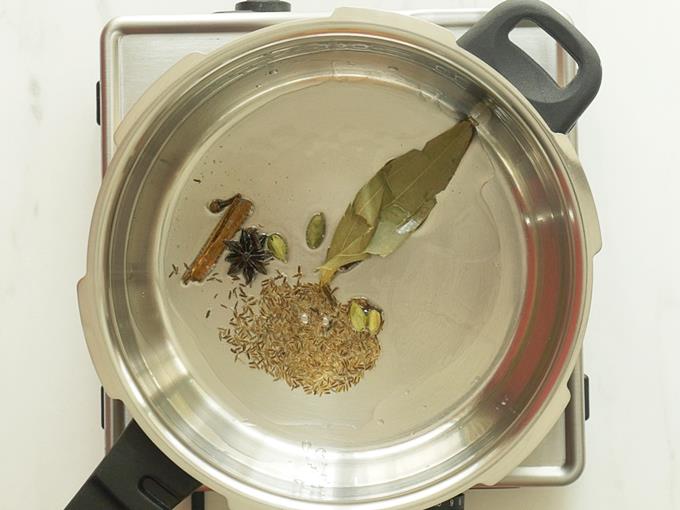 tempering spices in oil to make mushroom biryani