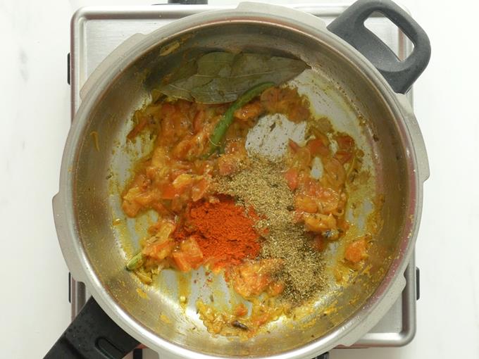 adding spice powders to make mushroom biryani