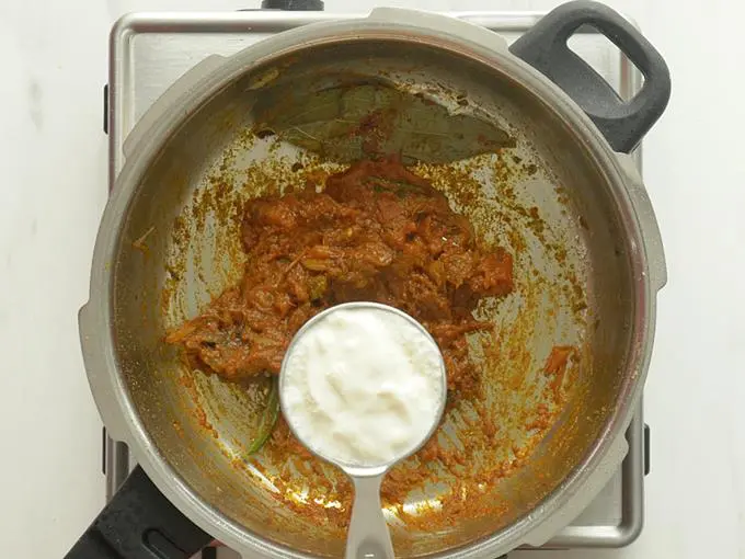 adding yogurt to make masala