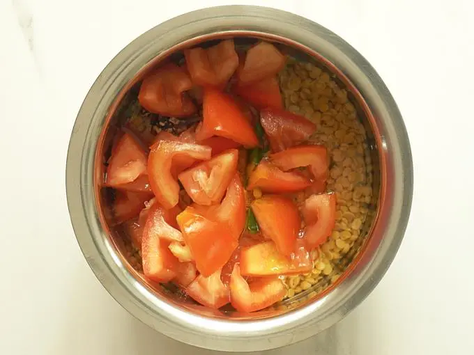 adding tomatoes to make tomato dal