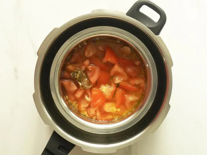 placing the bowl in pressure cooker to make tomato pappu