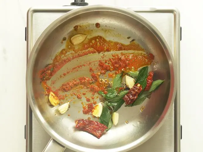 mixing the spices to add to tomato dal